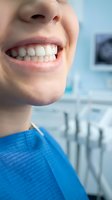 Close-up of smiling patient with healthy white teeth in dental office showing positive oral health care experience and professional treatment results.