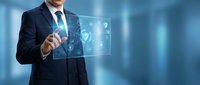 Professional businessman in dark suit touching futuristic holographic interface with security shield icons on blue background for technology presentations.