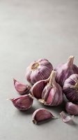 Fresh purple garlic bulbs and cloves arranged on neutral background for culinary cooking and healthy food preparation concepts.