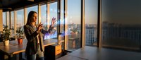 Professional businesswoman presenting in modern office with city skyline view during golden hour sunset for corporate meetings and presentations.