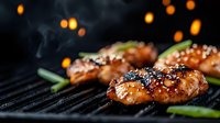 Juicy grilled chicken wings with sesame seeds and green onions on barbecue grill with smoke and bokeh lights in background, close up food photography.