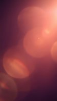 Soft bokeh circles in warm coral and burgundy tones create an abstract, dreamy background with blurred light effects. Perfect for overlays, presentations, and design projects.