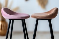 Modern bar stools with curved seats in pink and brown colors on black metal legs against light background, minimalist furniture design for contemporary interiors.