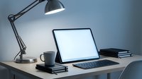Modern workspace with laptop computer, desk lamp and coffee mug on wooden table. Clean minimalist office setup for productivity and remote work.