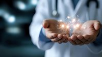 Medical professional in white coat holds glowing magical particles in cupped hands against dark background, representing healing energy and innovative healthcare.