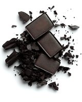 Dark brown eyeshadow palette with crushed powder texture scattered around on white background, makeup product photography for cosmetics advertising.