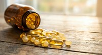 Amber glass bottle with yellow vitamin capsules spilled on wooden surface. Healthcare supplement concept for wellness and nutrition marketing materials.