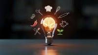 Glowing light bulb with culinary icons including chef hat, utensils, chili pepper and plant on dark background representing food innovation and creative cooking concepts.