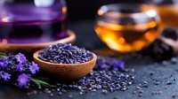 Dried lavender buds in wooden bowl with fresh flowers and herbal tea cups on dark background, aromatic herbs for relaxation and wellness spa.