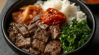 Grilled beef cubes with glazed vegetables and steamed rice in black bowl. Asian cuisine meal with broccoli and carrots ready for restaurant menu design.