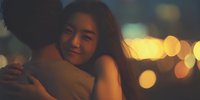 Young Asian woman embracing partner in warm evening light with beautiful bokeh background creating romantic intimate moment for relationship concepts.
