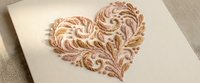 Elegant wooden heart with intricate carved swirl patterns on natural wood surface, perfect for romantic crafts, wedding decor and handmade gift projects.