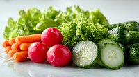Fresh organic vegetables arranged in row including carrots, radishes, sliced cucumber, and green lettuce leaves on light background, macro food photography.