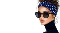 Young Caucasian woman wearing black turtleneck sweater, star pattern headscarf, and dark sunglasses against white background, fashion portrait with minimal style.