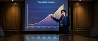 Professional businessman presenting corporate growth chart with upward trend arrow on large screen in modern conference room boardroom setting.
