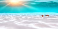 Underwater seascape with clownfish swimming over white sandy bottom against turquoise water and sun rays penetrating surface, marine life background.