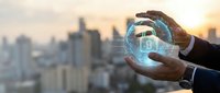 Businessman hands protecting digital padlock hologram over blurred city skyline at sunset representing cybersecurity and data protection concepts.
