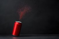 Red aluminum beverage can with sparkling water droplets floating against dark background, dramatic side lighting creates mysterious atmosphere for advertising.