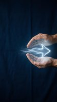 Mature male hands holding glowing electric arrow symbol against dark blue background, representing energy innovation, power technology, and sustainable electricity solutions.