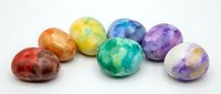 Colorful polished gemstone spheres in red, orange, yellow, green, blue, and purple isolated on white background for design, jewelry, wellness, and decorative projects.