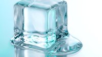 Crystal clear ice cube melting on reflective surface with water droplets and cool blue lighting for refreshing beverage and cooling concepts.