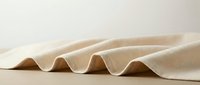 Elegant beige fabric with soft flowing waves creating natural folds and shadows on neutral background for textile and fashion design projects.