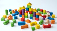 Colorful wooden building blocks scattered on white background. Educational toys for children development and creative play activities.