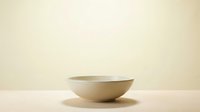 Minimalist ceramic bowl on wooden surface against neutral beige background for modern kitchen and dining room decor applications.