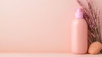 Pink cosmetic bottle with dried flowers and natural decoration on pastel background. Minimalist spa composition for beauty product presentation.
