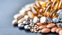 Assorted vitamin supplements and pills scattered on gray surface showcasing healthcare nutrition and wellness lifestyle choices for daily health routine.