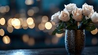 Elegant cream roses in textured black vase against blurred bokeh lights background, creating romantic evening atmosphere with soft warm glow and moody ambiance.