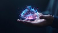 Glowing digital mountain range hologram floating above open palm, representing data analytics and future technology visualization.