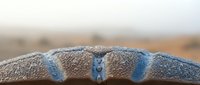 Water droplets on textured surface with soft blurred background creating natural moisture and freshness concept for wellness and purity themes.
