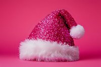 Glittery pink Santa hat with fluffy white fur trim and pom-pom, isolated on bright pink background for holiday designs and festive projects.