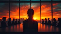 Silhouette of businesswoman looking at dramatic sunset through panoramic office window during corporate meeting with team members seated at conference table.