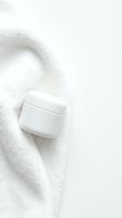 White cosmetic jar on soft cream textile, minimalist skincare product presentation for beauty and wellness branding.