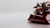 Elegant gift wrapped in metallic copper ribbon and bow against soft neutral background, creating luxurious holiday or celebration atmosphere.