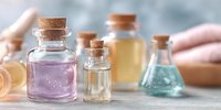 Small glass bottles with cork stoppers containing colorful liquids and crystals for aromatherapy, essential oils, and natural wellness treatments.
