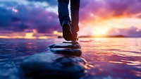 Person walking barefoot on stones in water during dramatic sunset, purple and orange sky reflecting on ocean surface, spiritual wellness concept for meditation and mindfulness.