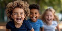 Joyful diverse children laughing and playing outdoors. Mixed race kids with natural curly and blonde hair showing genuine happiness and friendship in casual wear.