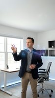 Professional Caucasian businessman in navy blazer interacting with holographic digital interface icons in modern office workspace for technology presentations.