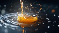 Orange liquid drop splashing and creating crown-shaped ripples with water droplets scattering against dark background, captured in macro photography with dramatic lighting.