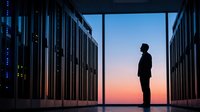 Male IT professional silhouette standing in modern data center server room at sunset. Technology infrastructure and cloud computing concept for business.