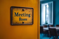 Vintage meeting room sign on yellow wall with blurred conference space in background, creating professional office atmosphere with retro design elements.