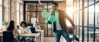 Man holding percentage symbol in modern office with colleagues working at desks, representing business growth, financial success, and corporate performance metrics for marketing and advertising.