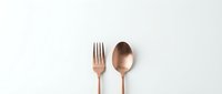 Elegant copper rose gold fork and spoon flatware set on clean white background for modern kitchen dining and restaurant branding design projects.