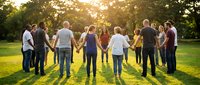 Diverse group of people holding hands in circle on sunny green grass field, symbolizing unity, teamwork, community support and togetherness for corporate or nonprofit campaigns.