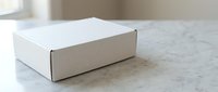 White cardboard shipping box on marble surface for e-commerce packaging and delivery services in modern minimalist setting.