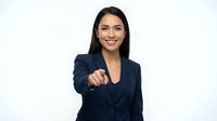 Professional Hispanic businesswoman in navy suit pointing forward with confident smile on white background for corporate presentations and marketing.