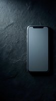Modern smartphone with blank screen on dark slate stone surface, top view. Mockup for app or website presentation.